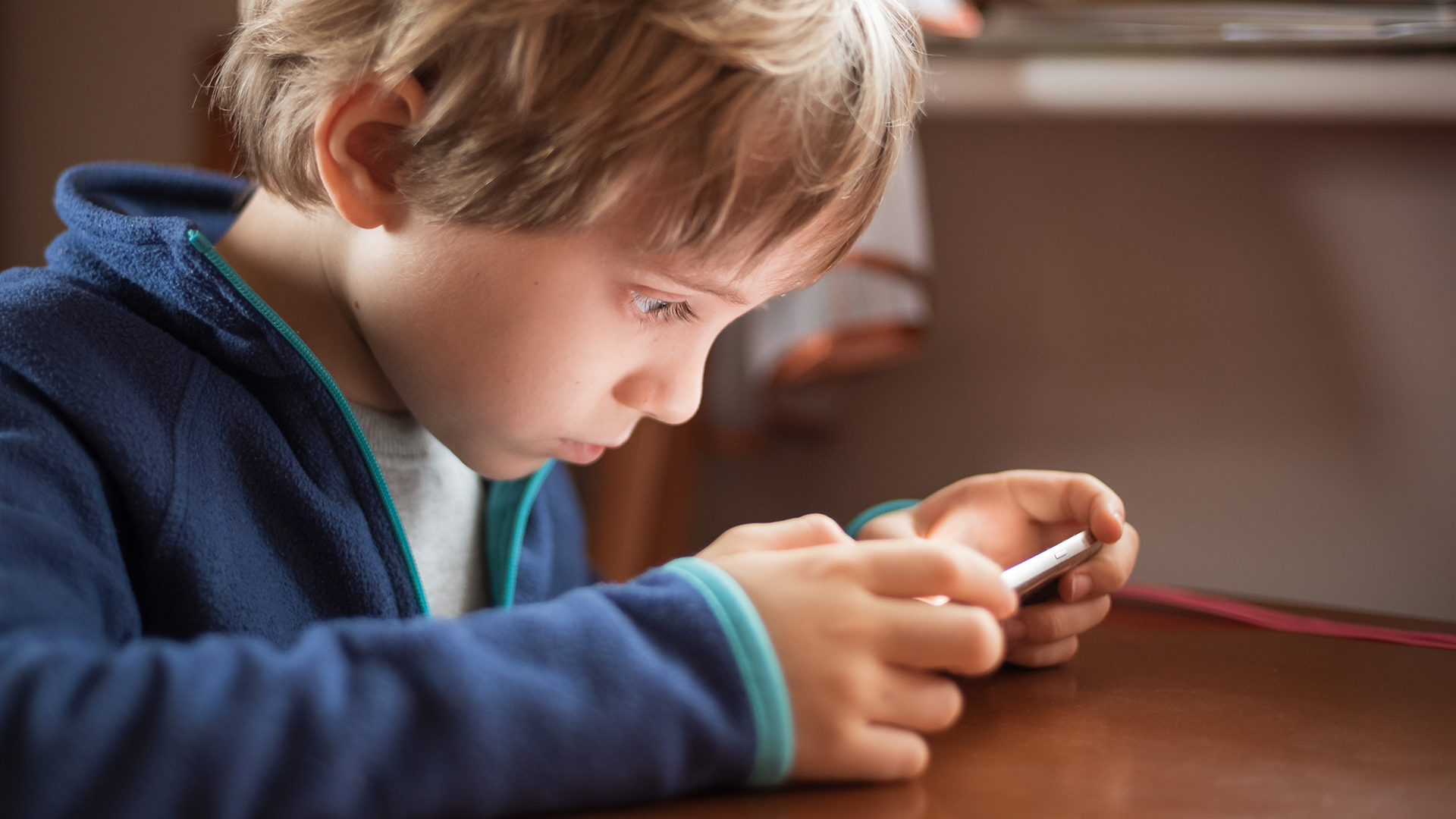 Un enfant d'âge scolaire accaparé par ce qu'il voit sur un écran