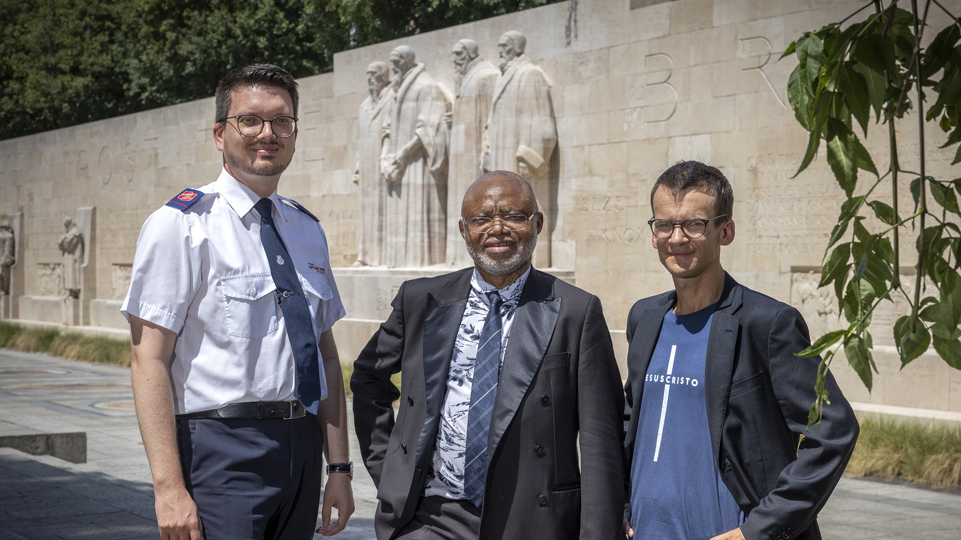 les trois recourants devant le Mur des réformateurs à Genève